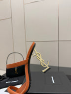 Orange YSL mule sandal with gold YSL logo on the heel and open toe.