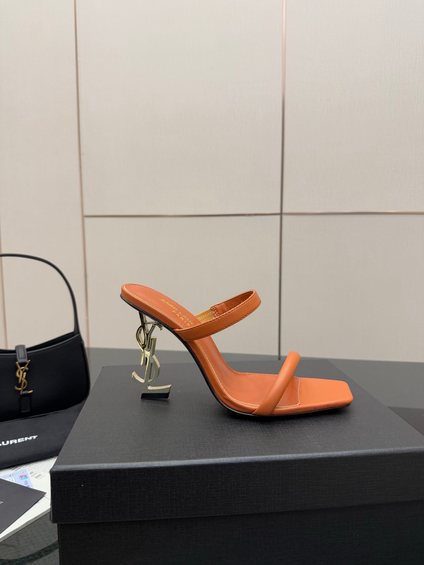 Orange YSL mule slide sandal with open toe and sculpted block heel, shown on box.