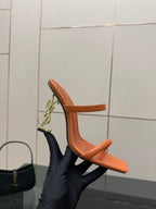 Orange YSL slide mule sandal with open toe and sculpted block heel, side angle.