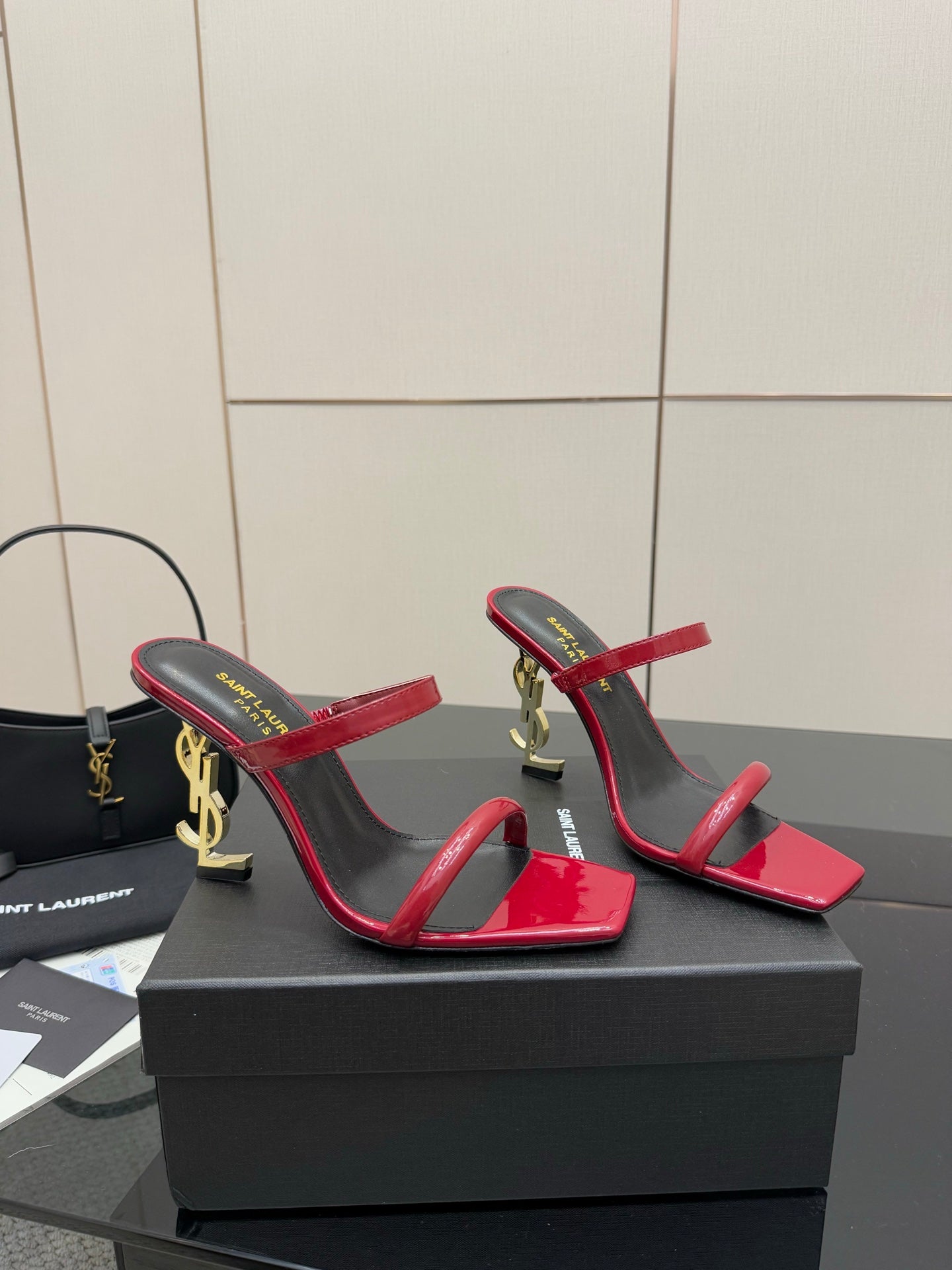 YSL ladies heeled sandals side view, red patent straps with gold logo on heel