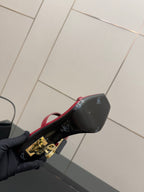 YSL ladies sandal heel close-up, gold YSL emblem on black heel and red strap