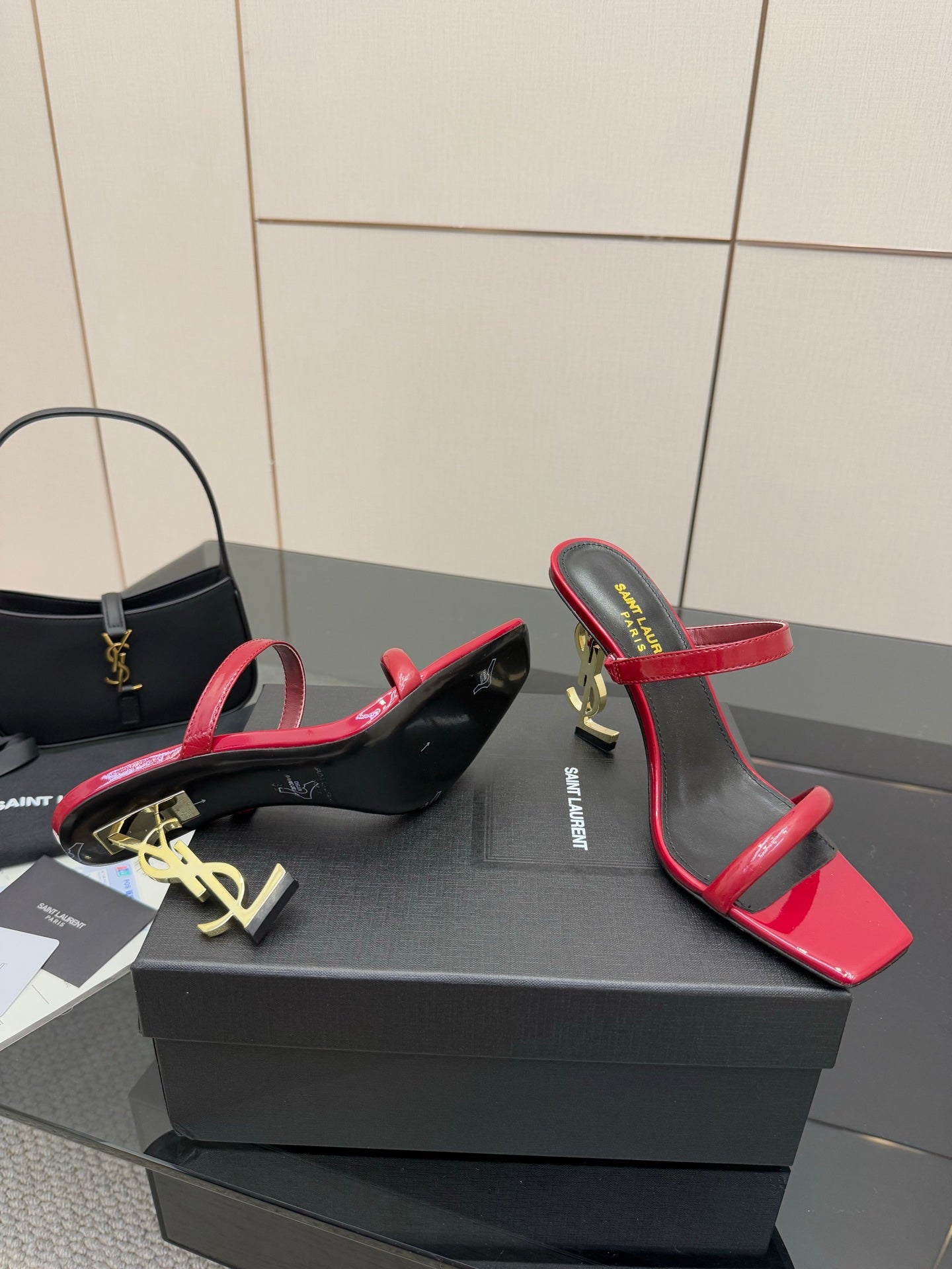 YSL ladies heeled sandals, angled view, red straps and black footbed with gold logo
