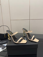 Two-tone heeled mule sandals, black lining with beige strap across the toes