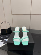 Mint green heeled mule sandals with gold logo detail and wide toe straps