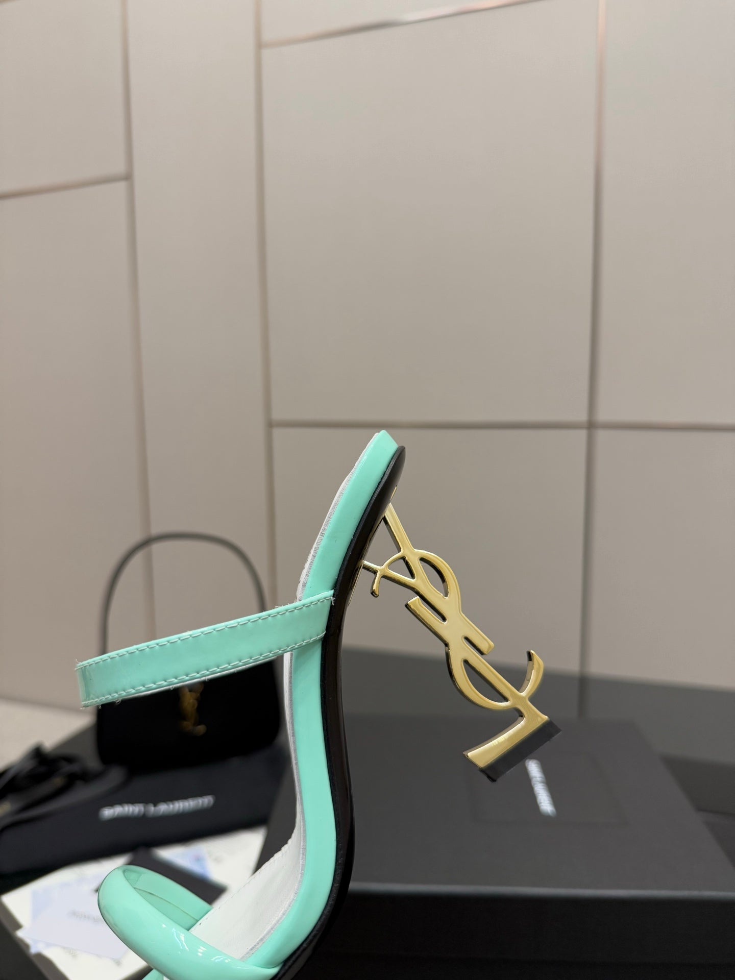 Mint green heeled mule with gold logo on the heel and open toe