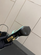 Black heeled mule sandal with gold logo detail and mint green sole edge
