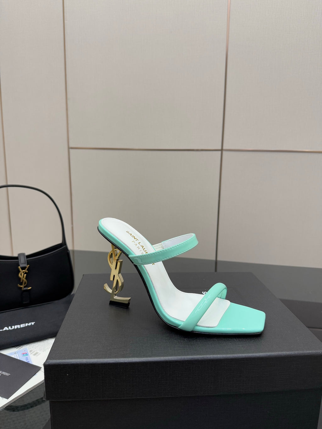 Mint green heeled mules with open toe, slim strap, and gold logo heel