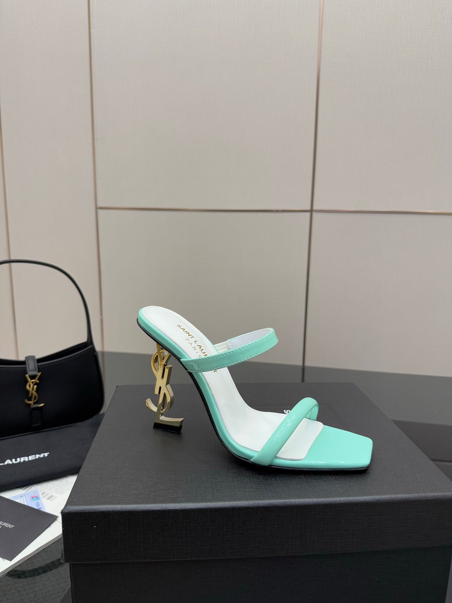 Mint green heeled mules with open toe, slim strap, and gold logo heel