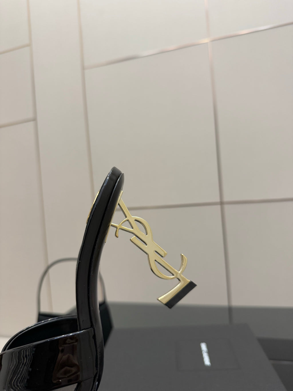 Black patent mule heel with gold logo emblem on the side