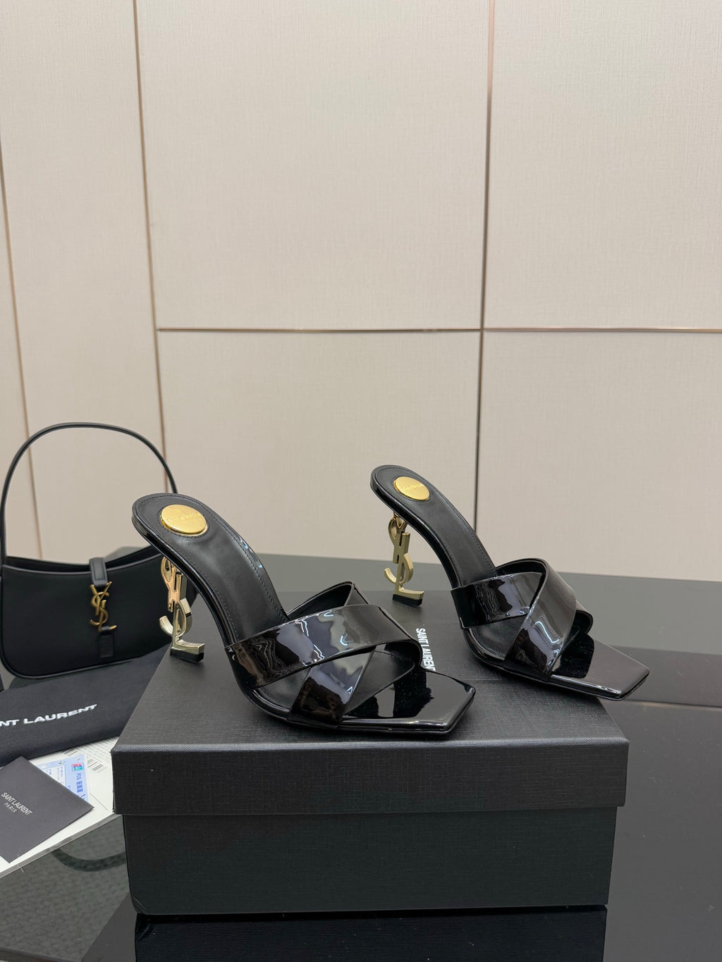 Black patent mule sandals with squared open toe and gold heel hardware