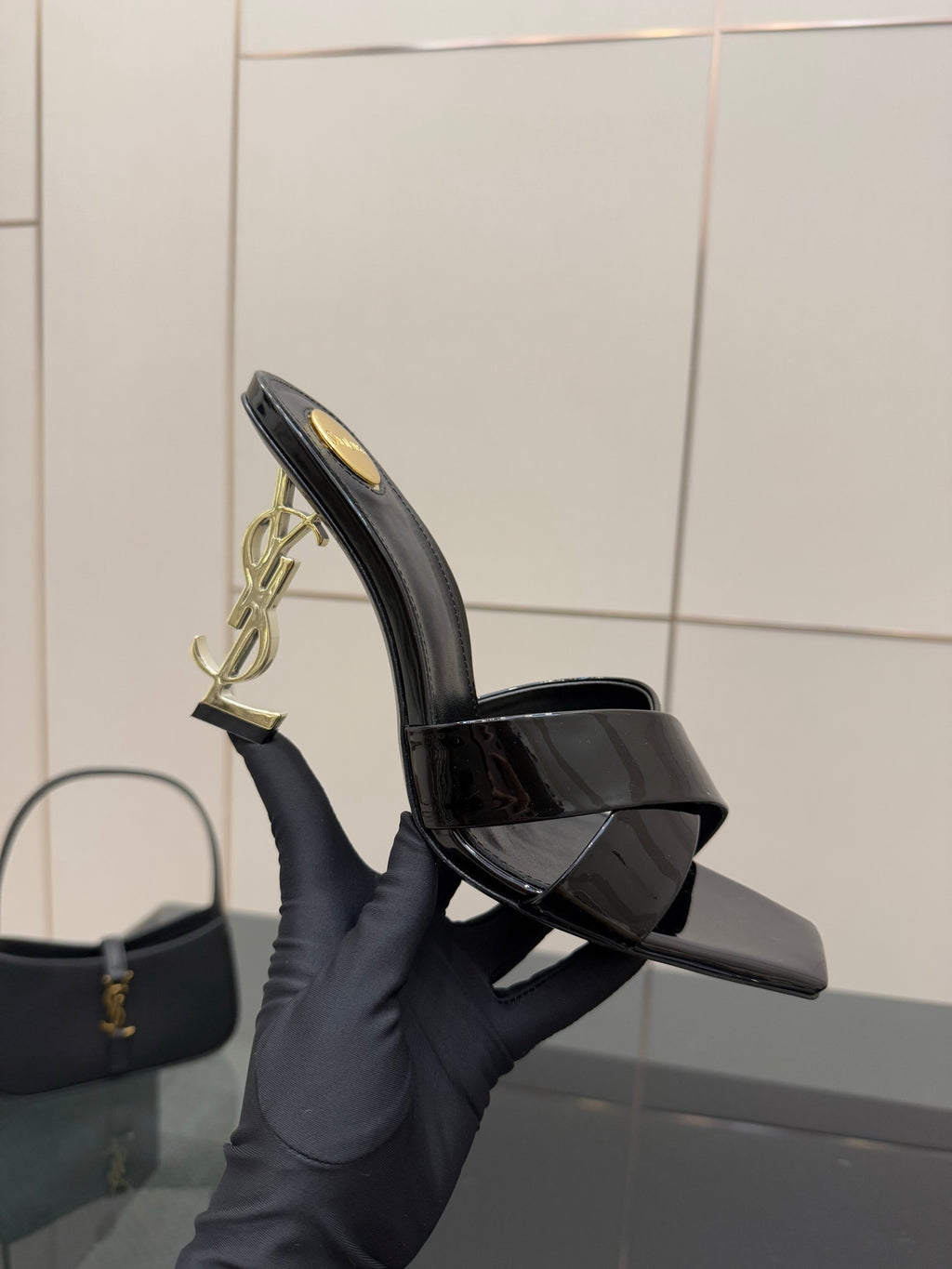 Black patent mule sandal with open toe platform and gold logo hardware