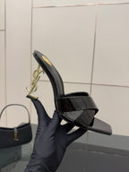 Black patent mule sandal with open toe platform and gold logo hardware