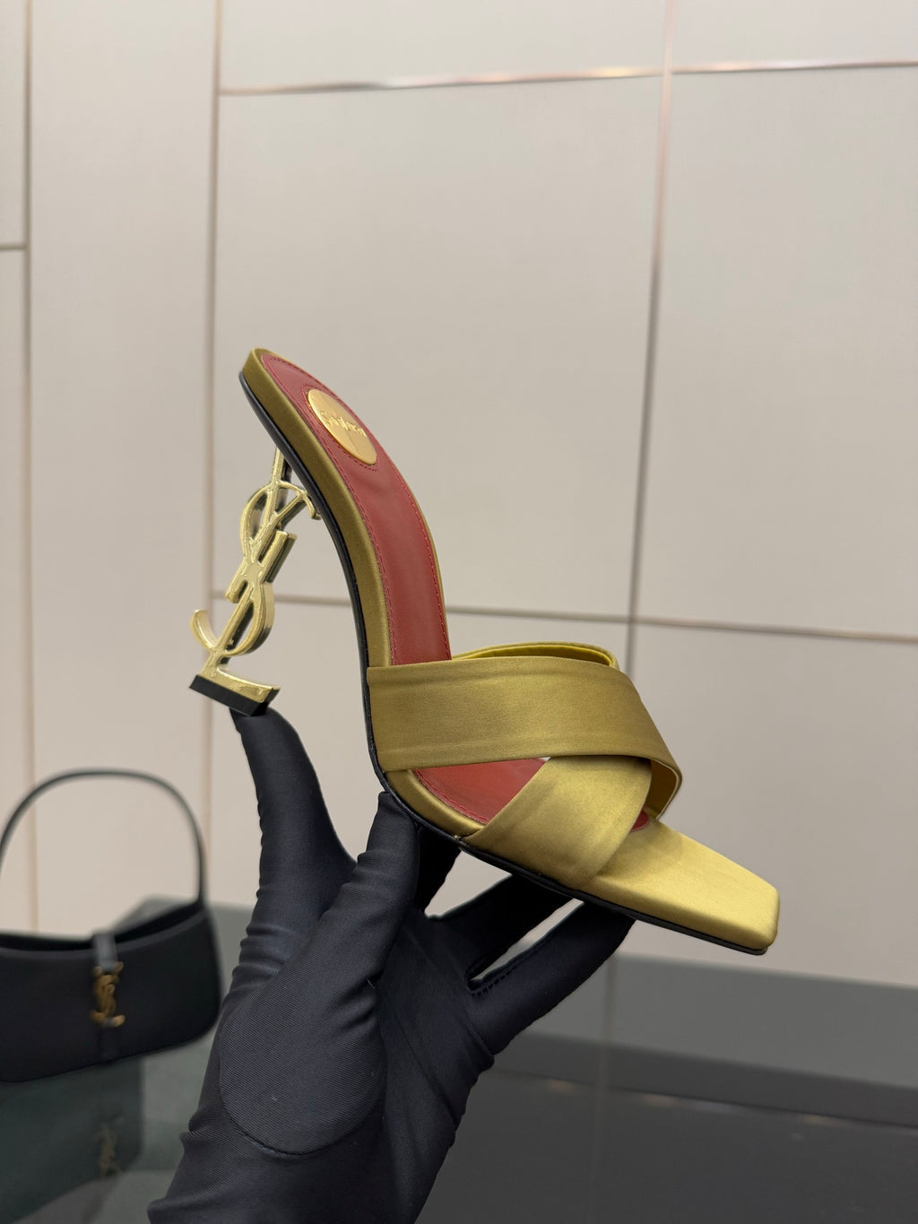 Black mule sandal with gold YSL-style logo heel detail, open-toe slide