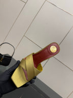 Yellow mule sandal with red insole and gold coin logo on heel
