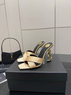 Cream and dark heeled mule sandals with gold YSL logo detail on heel, pair on box.