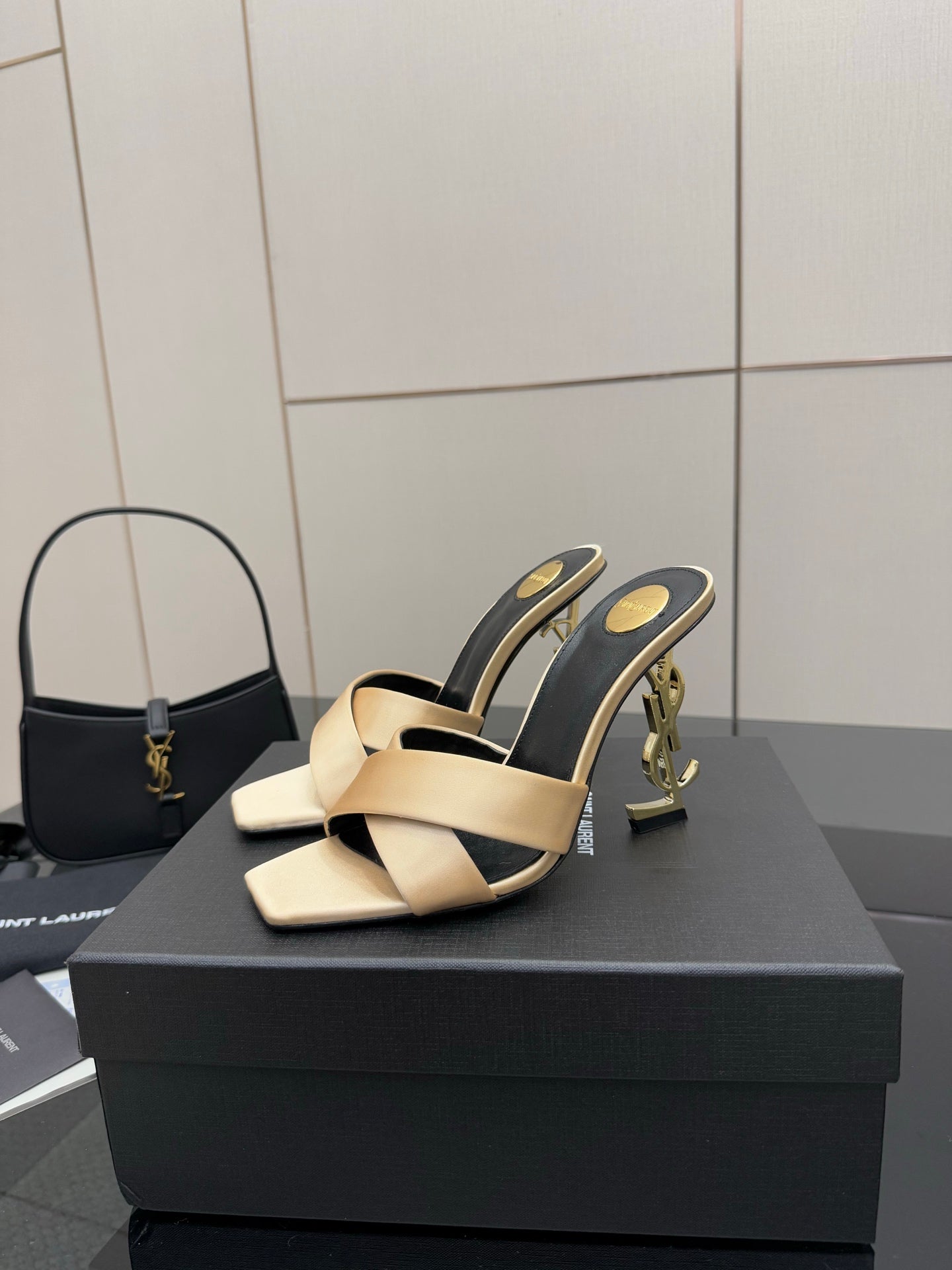 Cream and dark heeled mule sandals with gold YSL logo detail on heel, pair on box.