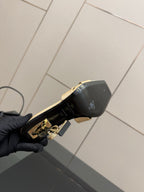 Heeled mule sandal outsole view with black underside and gold YSL logo detail.