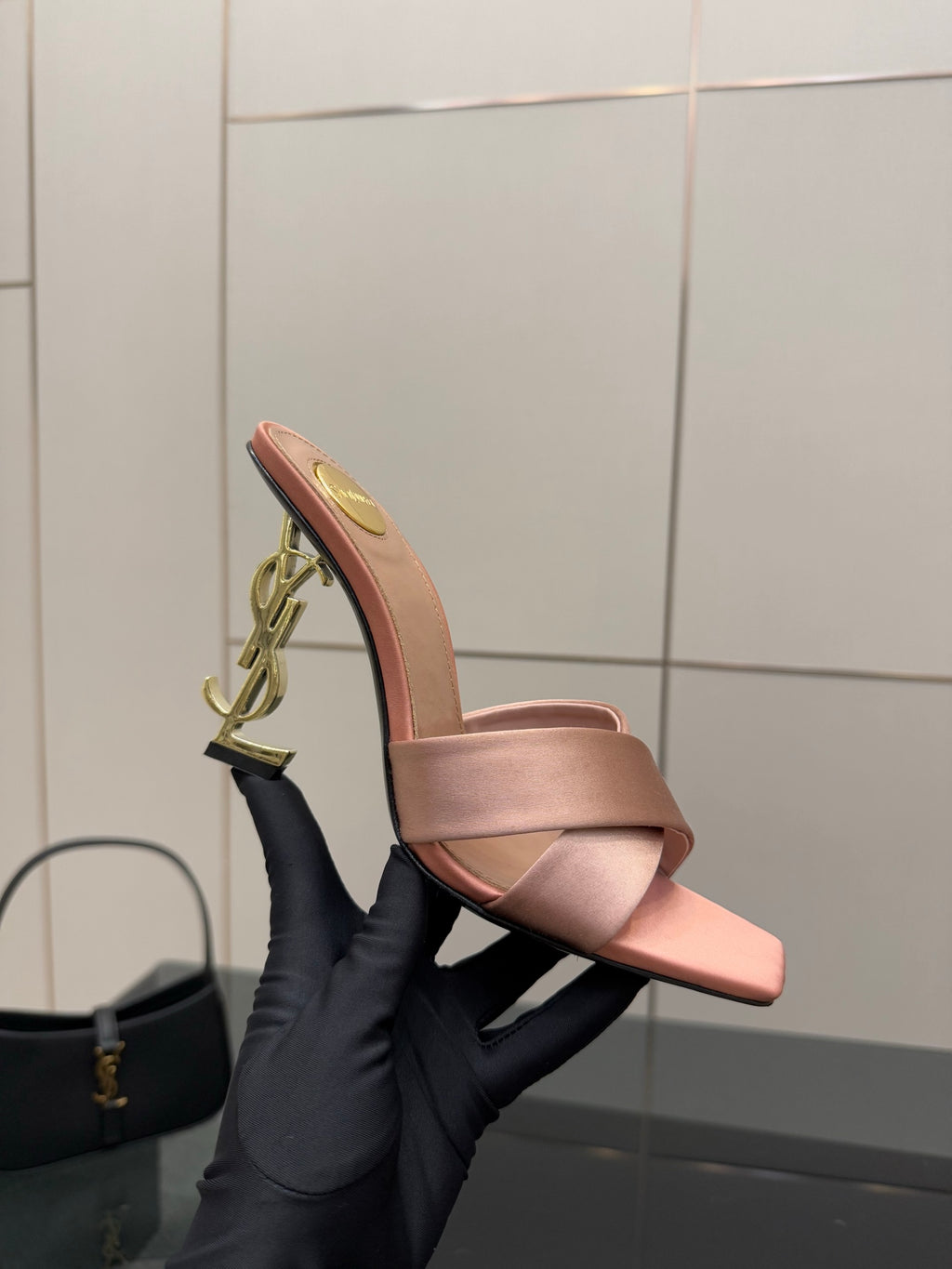 Pink YSL logo slide sandals, side profile showing gold chain-style emblem
