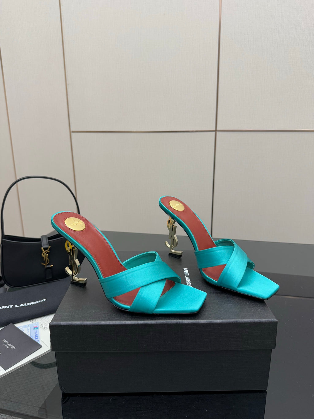 Pair of teal YSL mule sandals, open toe and mid-height block heels with gold accents