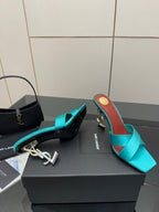 Teal YSL mule sandal with open toe and block heel, gold logo on the heel