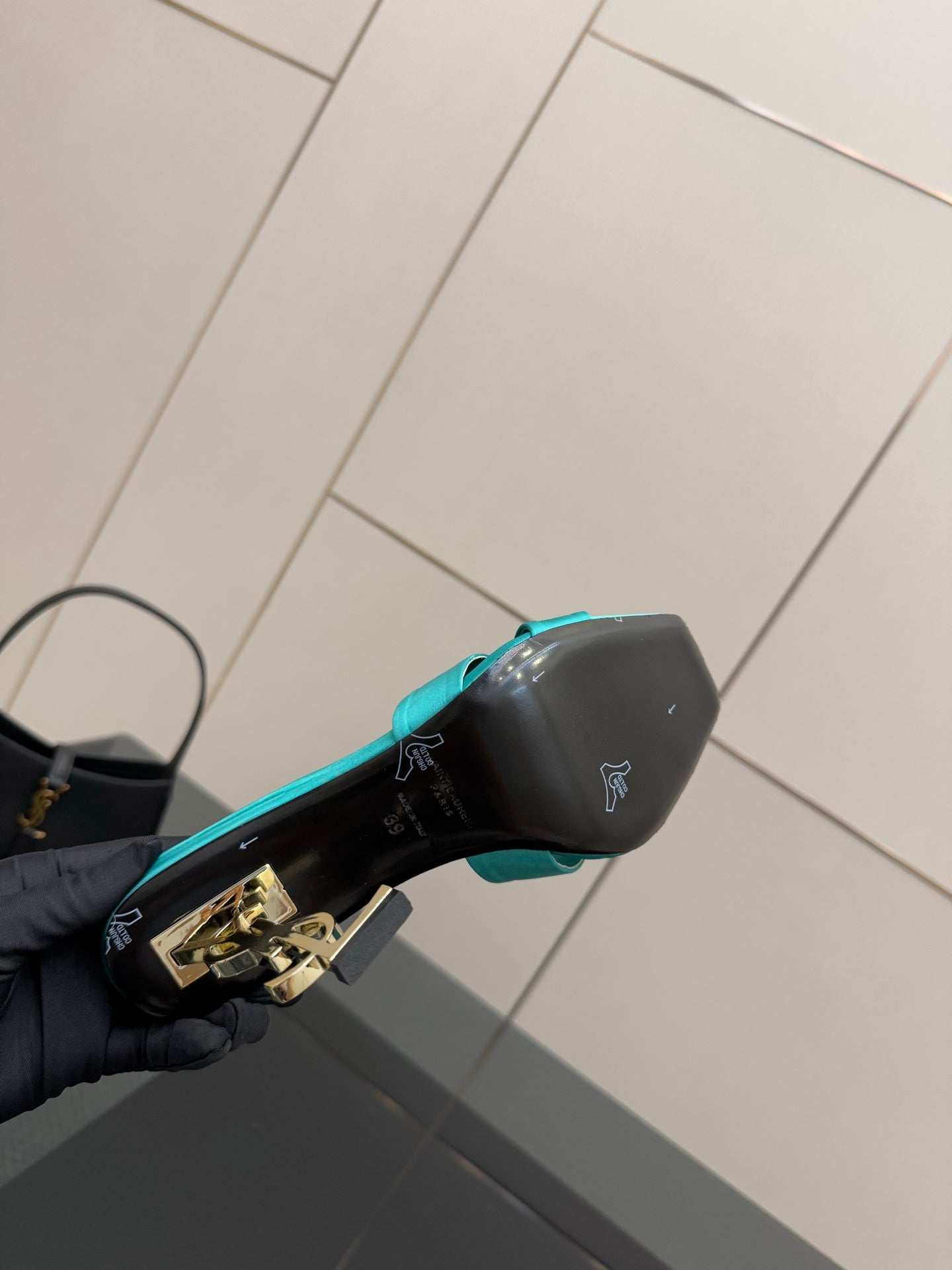 Teal and black YSL mule sandal side view with gold logo on heel block