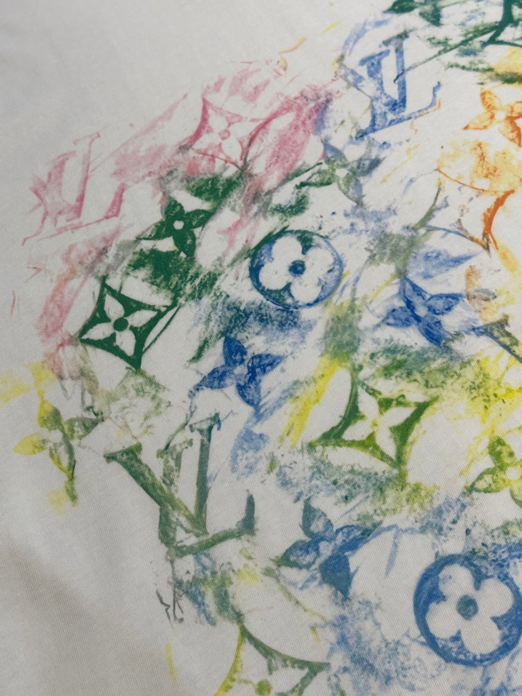 Multicolor graphic print on white T-shirt, featuring blue motif and green accents
