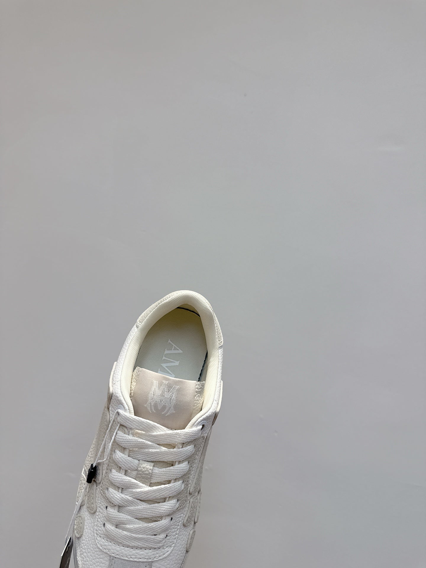 White sneakers close-up, showing laces and interior lining near the collar
