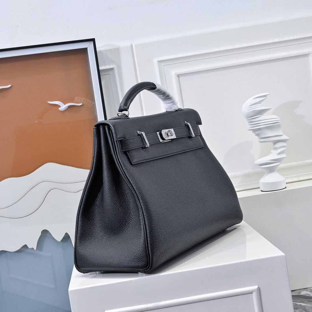 Black leather structured handbag with top handle, front flap and silver hardware