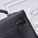 Black pebbled leather handbag with flap clasp and stitched panel detail