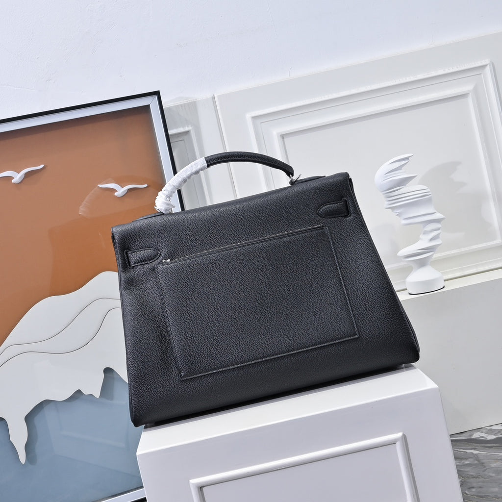 Black leather handbag with top handle, front panel detail and silver clasp hardware