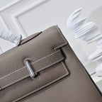 Hermes handbag taupe leather, close-up of front strap and metal snap hardware