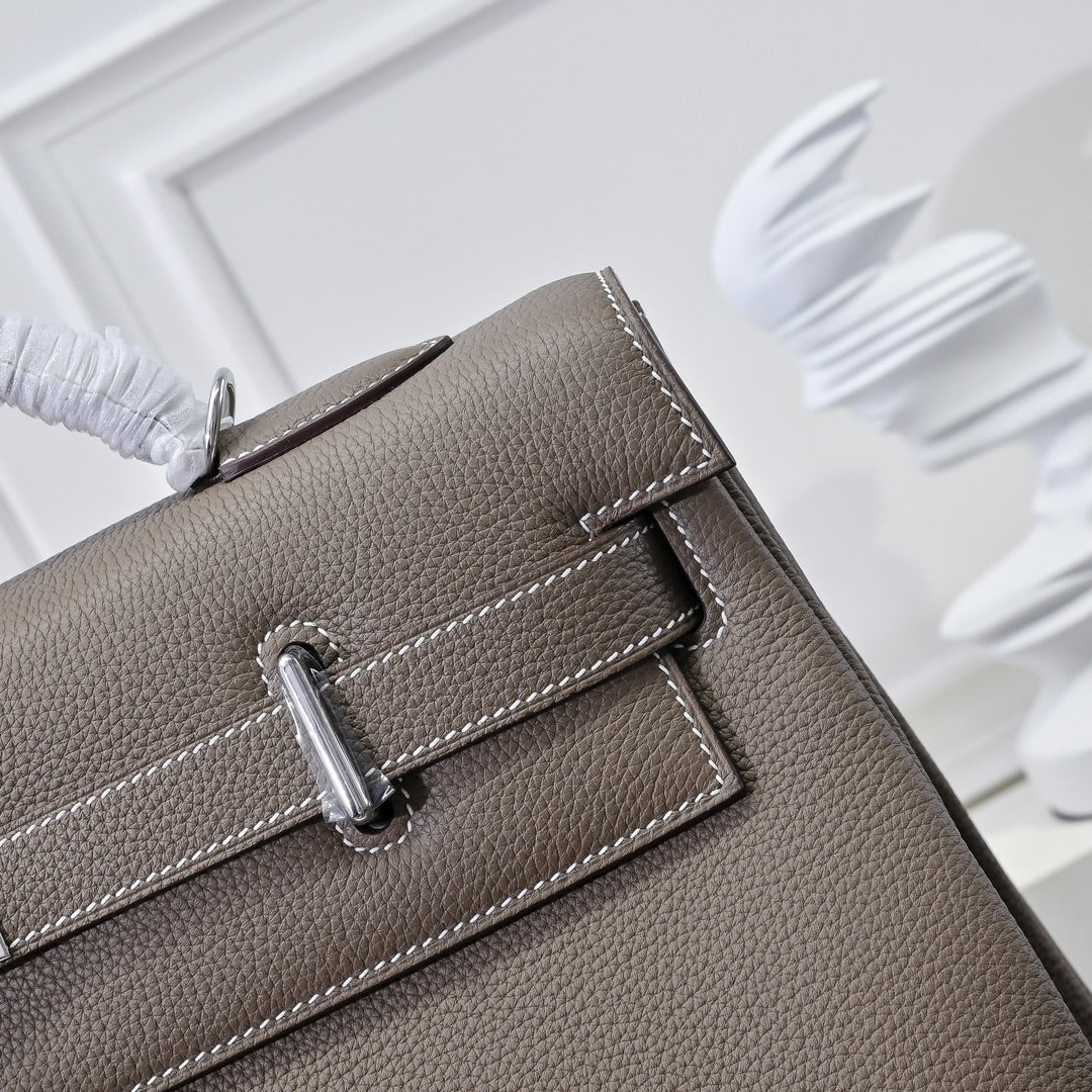 Hermes handbag taupe leather, close-up of front strap and metal snap hardware