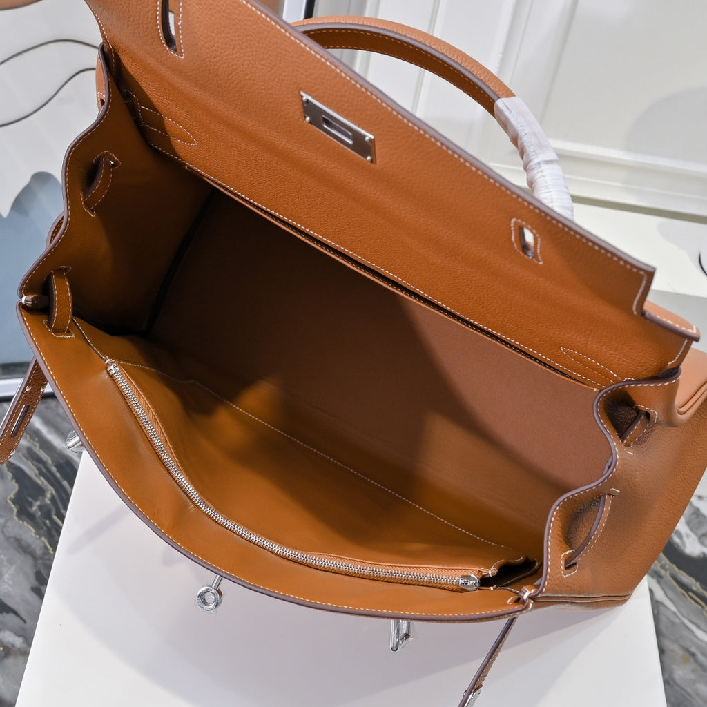 Hermes leather bag interior view in tan-brown with top edges and drawstring tassel.