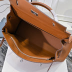 Hermes leather bag interior view in tan-brown with top edges and drawstring tassel.