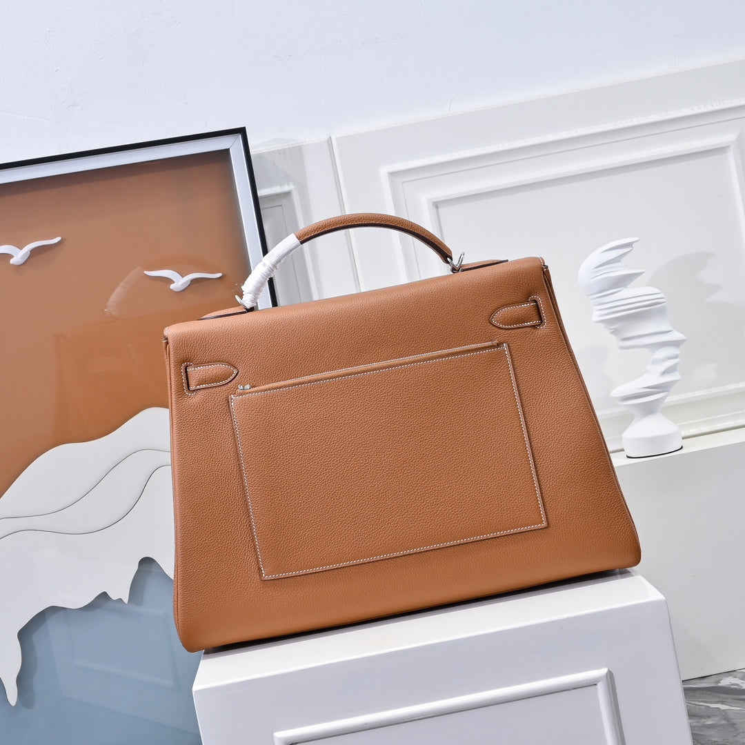 Hermes leather bag in tan-brown with front rectangular panel and top handle strap.