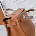 Hermes leather bag in tan-brown with open top and visible interior lining and hardware.
