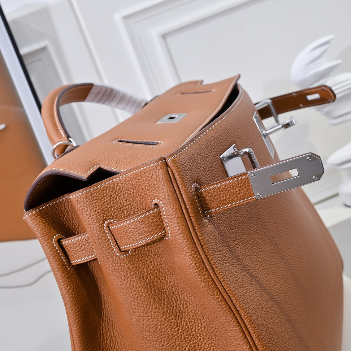 Hermes leather bag in tan-brown with open top and visible interior lining and hardware.