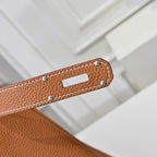 Hermes leather bag in tan-brown with stitched strap edge and silver-toned rivets.
