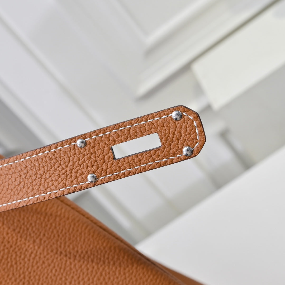 Hermes leather bag in tan-brown with stitched strap edge and silver-toned rivets.