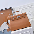 Hermes leather bag in tan-brown with top handle and front flap lock detail.