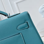 Turquoise leather handbag close-up of stitched flap pocket detail and trim