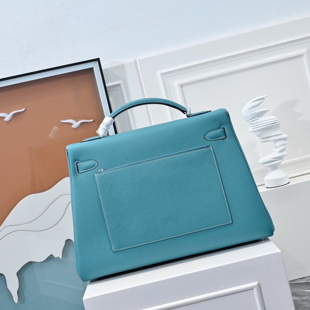 Turquoise leather handbag with front flap pocket and structured rectangular shape