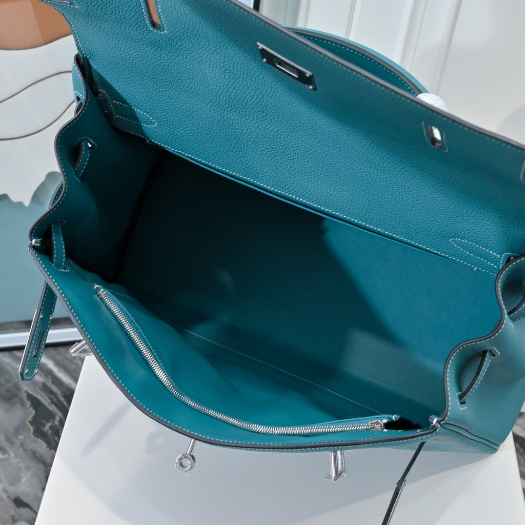 Turquoise leather handbag interior view with zip pocket and side strap hardware
