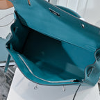 Turquoise leather handbag interior view with zip pocket and side strap hardware