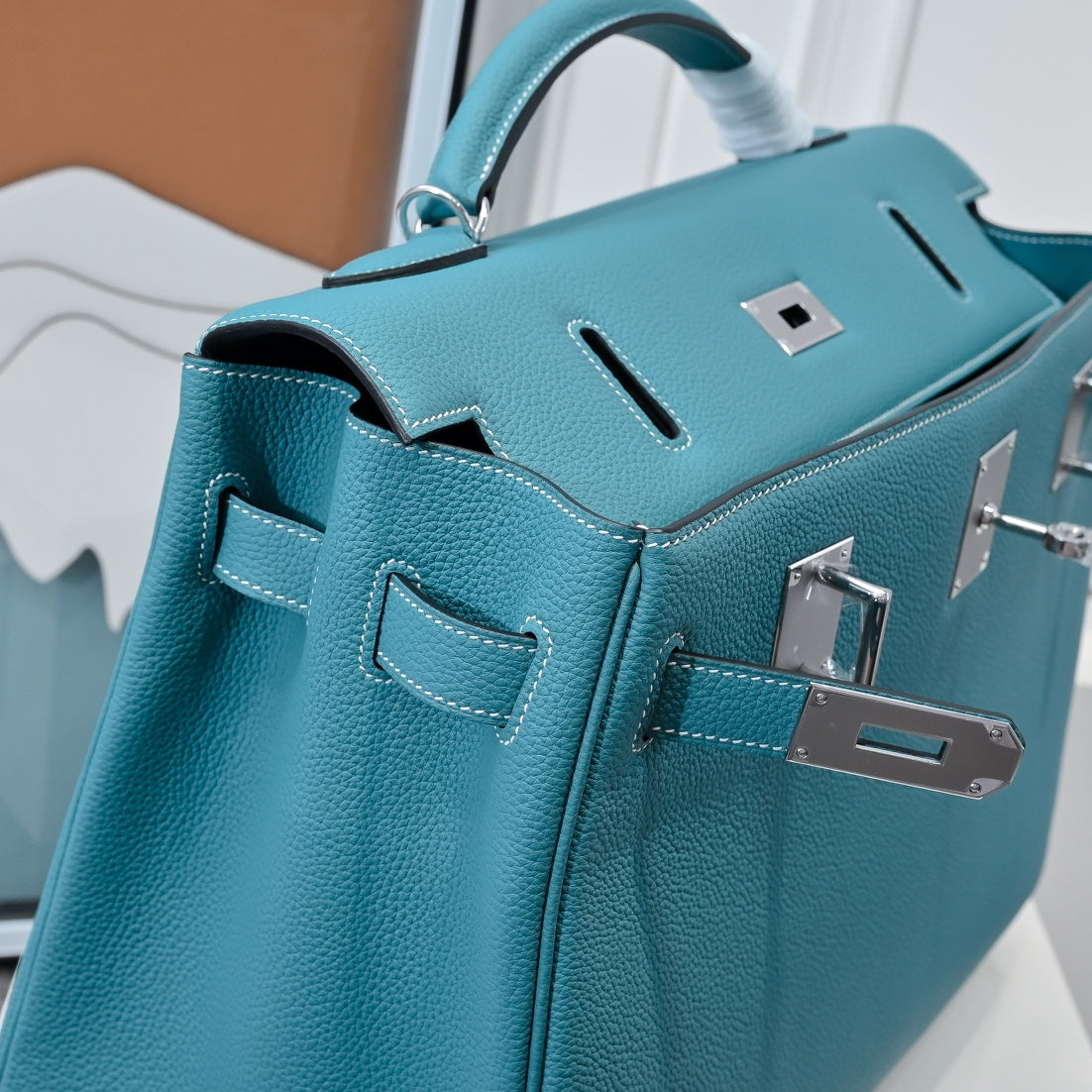 Turquoise leather handbag close-up of front hardware latch and gusset details