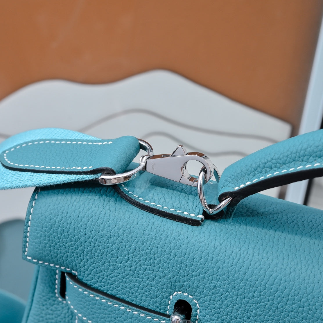 Turquoise leather handbag close-up of top strap loop and silver clasp hardware