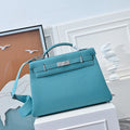 Turquoise leather Kelly-style handbag with top handle and front flap clasp