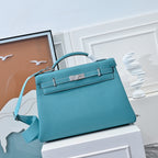 Turquoise leather Kelly-style handbag with top handle and front flap clasp
