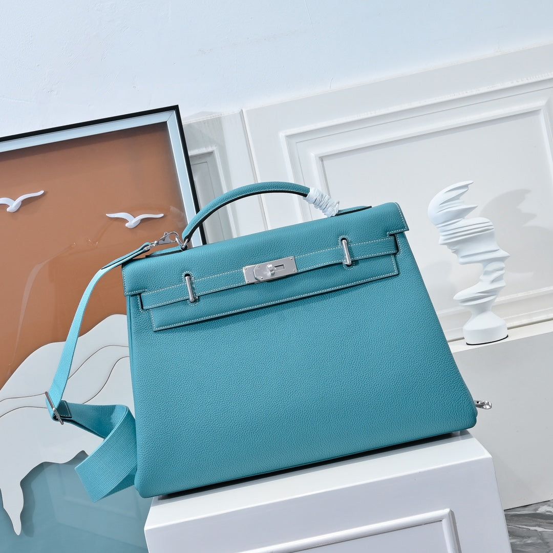 Turquoise leather Kelly-style handbag with top handle and front flap clasp