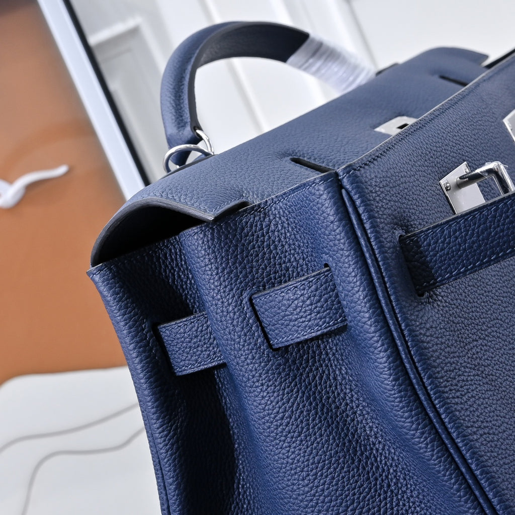 Hermes bag dark blue leather with top handle, front flap, and stitched side panels